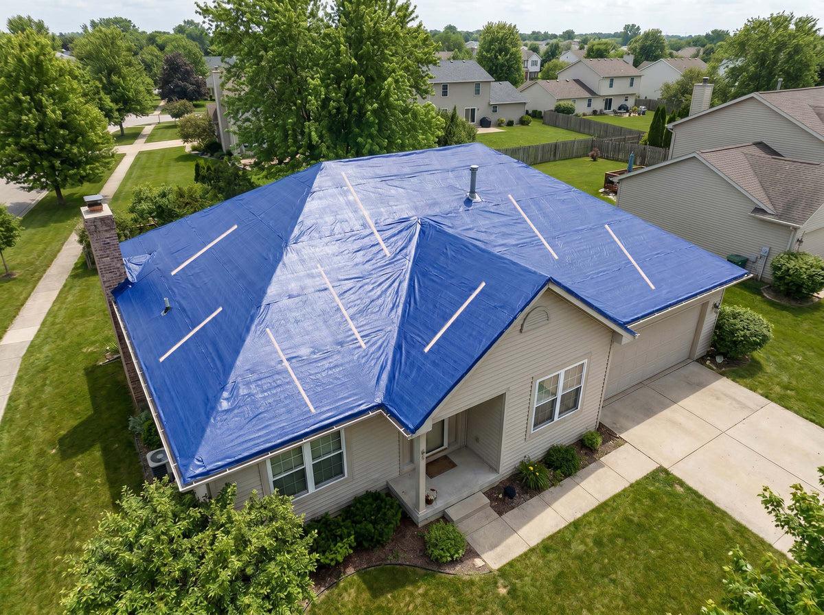 Emergency tarp secured with wood battens on a Boerne home after wind damage
