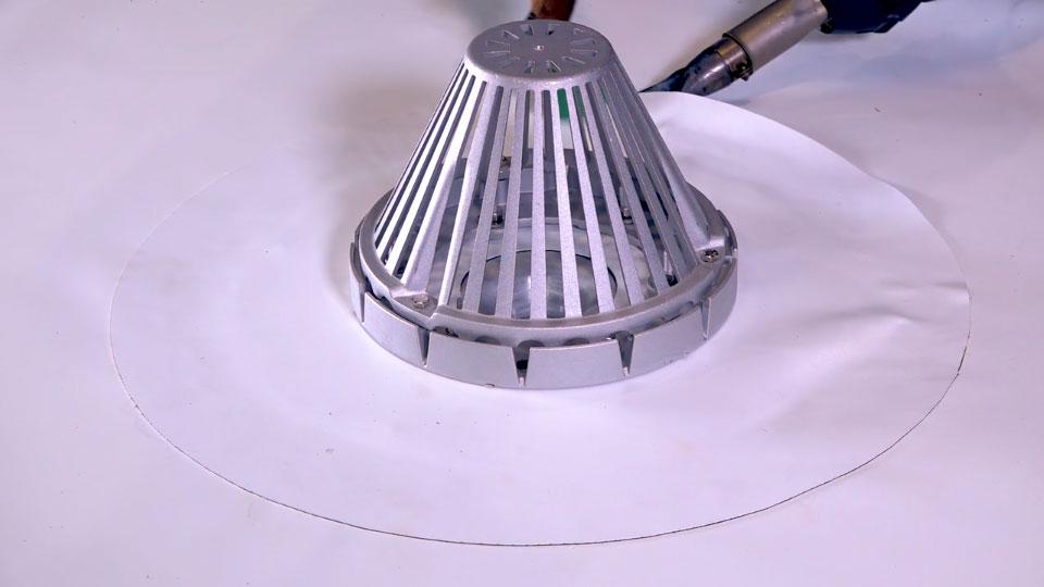 Heat-welded TPO seam and roof drain detail on a flat roof near Boerne