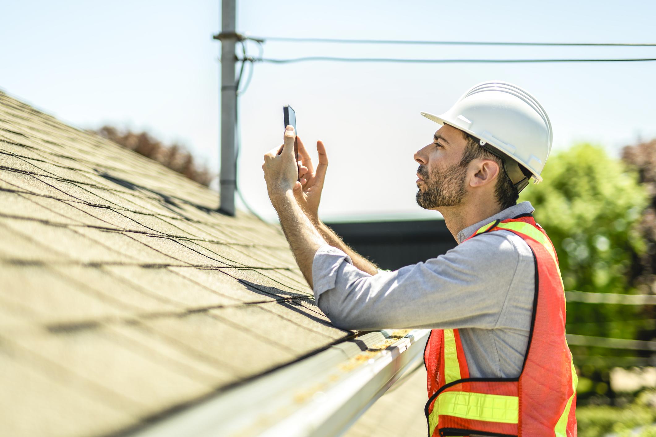 A1 Boerne Roofing inspector and an insurance adjuster reviewing hail damage together on a Boerne roof