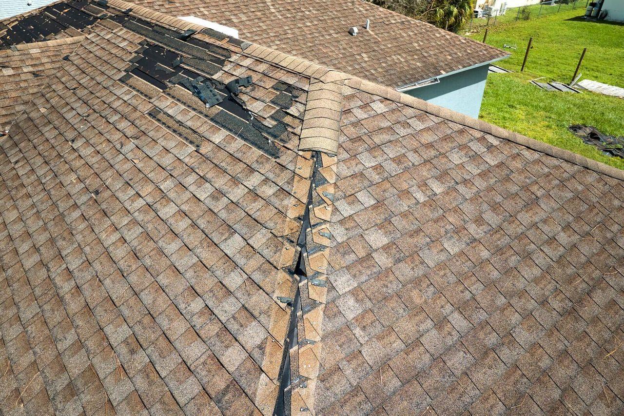 Ridge cap shingles blown off by straight-line wind on a Boerne roof
